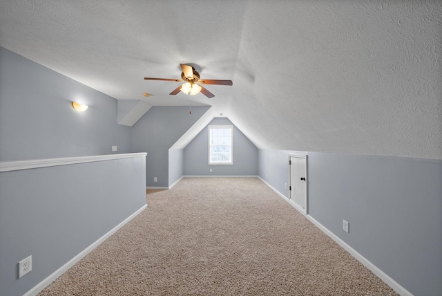 bonus room featuring a textured ceiling, carpet flooring, and lofted ceiling