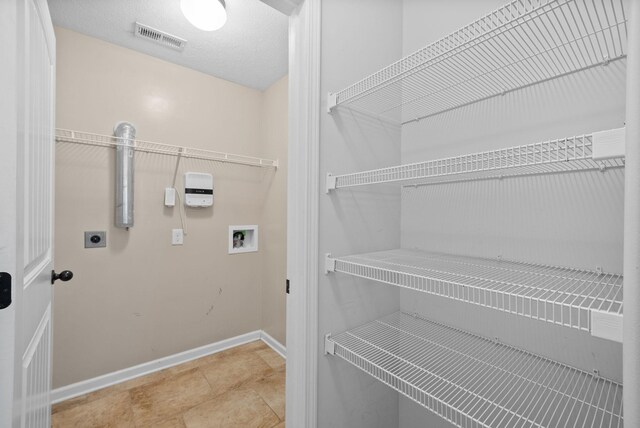 laundry room featuring washer hookup, visible vents, electric dryer hookup, laundry area, and baseboards