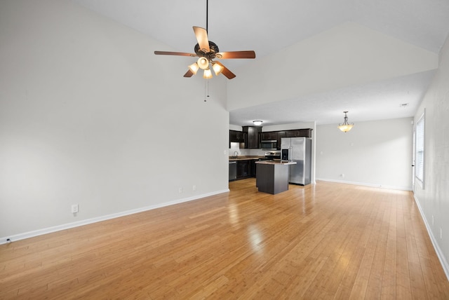 unfurnished living room featuring high vaulted ceiling, light wood-style flooring, baseboards, and a ceiling fan