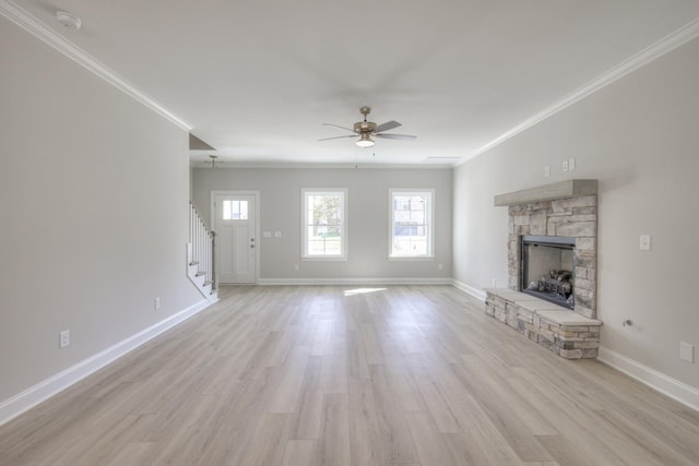 unfurnished living room featuring ornamental molding, a stone fireplace, ceiling fan, and light hardwood / wood-style floors