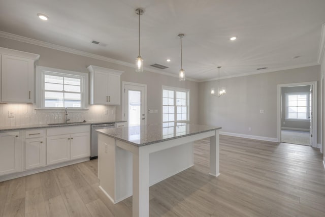 kitchen with white cabinetry, dishwasher, sink, a center island, and light stone counters