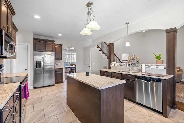 kitchen with dark brown cabinetry, sink, a kitchen island, pendant lighting, and stainless steel appliances