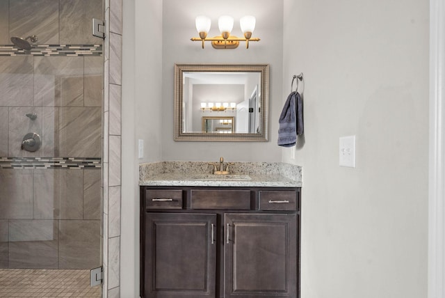 bathroom featuring a shower with door and vanity