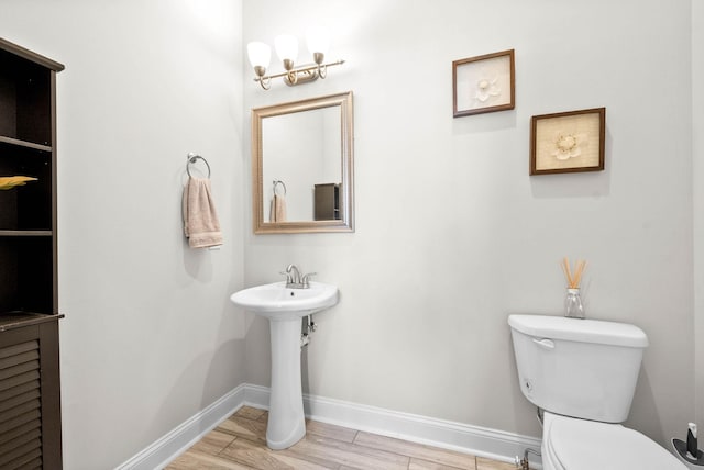 bathroom with sink, toilet, and hardwood / wood-style floors