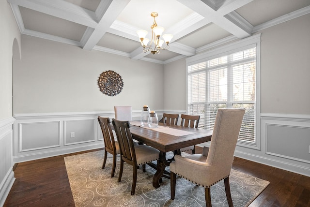 dining room with dark wood-type flooring, coffered ceiling, crown molding, a chandelier, and beam ceiling