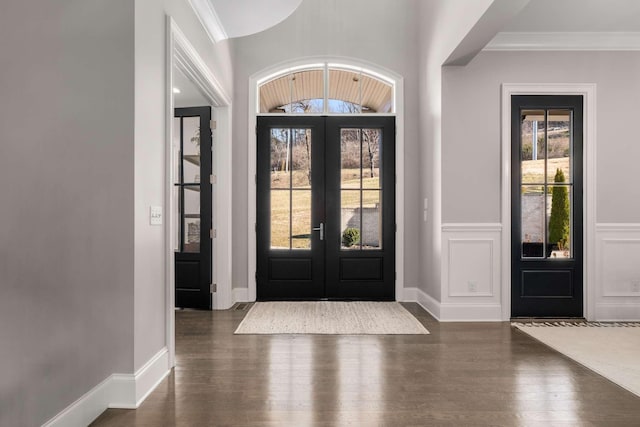 entrance foyer featuring ornamental molding, lofted ceiling, dark hardwood / wood-style flooring, and french doors