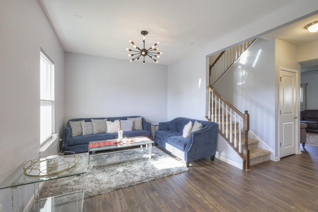 living room featuring wood-type flooring and an inviting chandelier