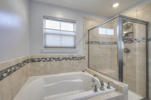 bathroom featuring shower with separate bathtub