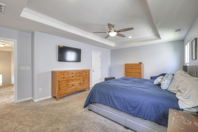 bedroom with a tray ceiling, ornamental molding, light colored carpet, and ceiling fan