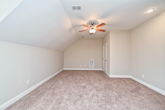 additional living space featuring light carpet, lofted ceiling, and ceiling fan