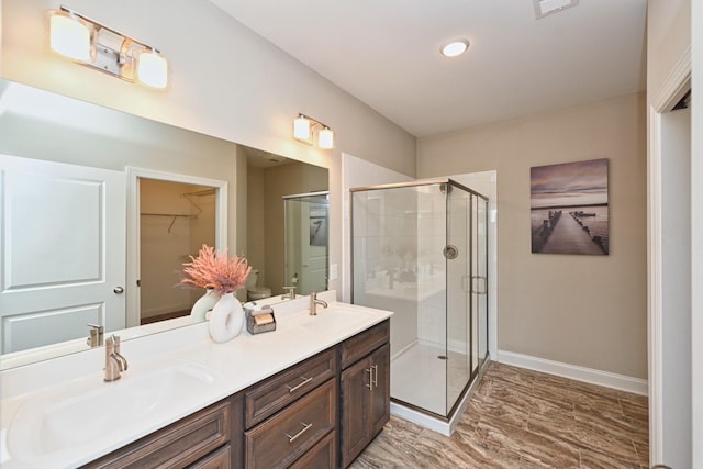 bathroom featuring vanity, wood-type flooring, and a shower with door