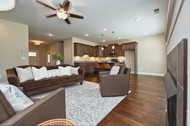 living room with ceiling fan, dark hardwood / wood-style floors, and sink