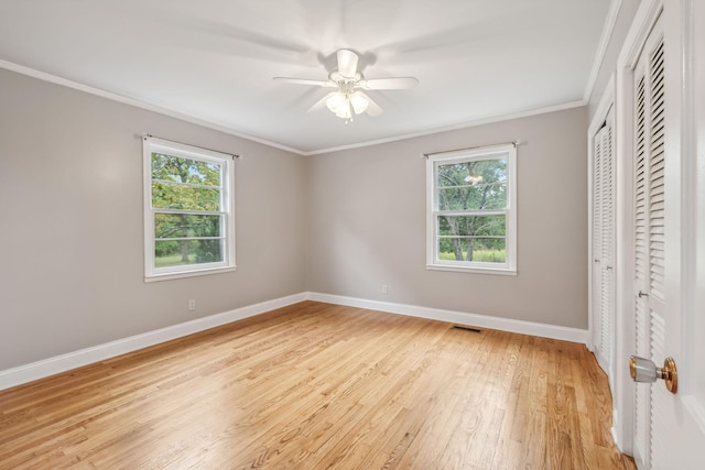 unfurnished bedroom featuring crown molding, ceiling fan, light hardwood / wood-style floors, and a closet