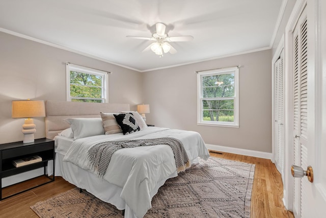 bedroom with crown molding, a closet, ceiling fan, and light hardwood / wood-style flooring