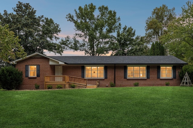 ranch-style home featuring a yard and a deck