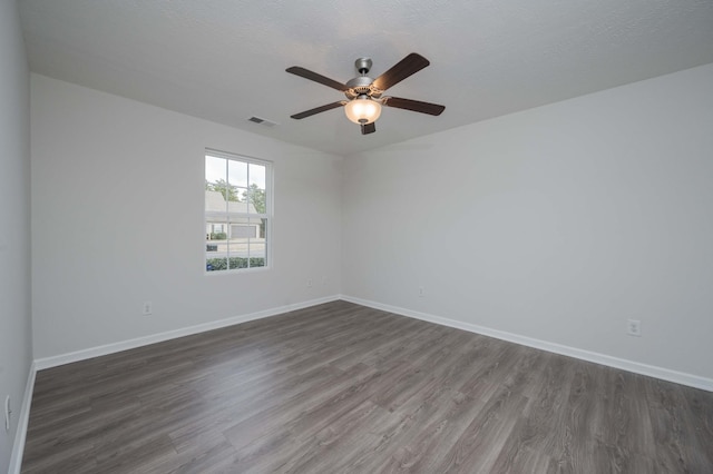 spare room featuring ceiling fan, dark hardwood / wood-style floors, and a textured ceiling