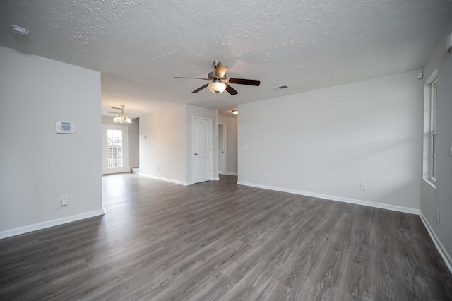 spare room with dark hardwood / wood-style flooring, ceiling fan with notable chandelier, and a textured ceiling