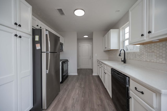 kitchen featuring white cabinetry, sink, tasteful backsplash, and black appliances