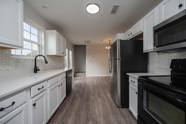 kitchen featuring sink, black appliances, dark hardwood / wood-style floors, and white cabinets