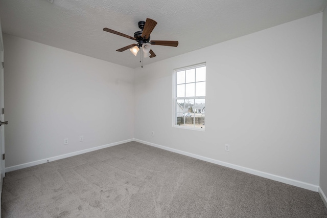 carpeted empty room with ceiling fan and a textured ceiling