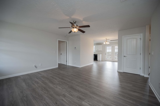 unfurnished living room featuring dark hardwood / wood-style flooring, ceiling fan with notable chandelier, and a textured ceiling