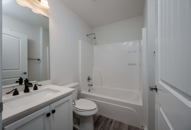 full bathroom with toilet, tub / shower combination, a textured ceiling, vanity, and hardwood / wood-style floors