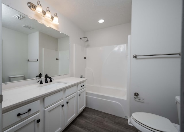 full bathroom featuring shower / tub combination, vanity, a textured ceiling, and toilet