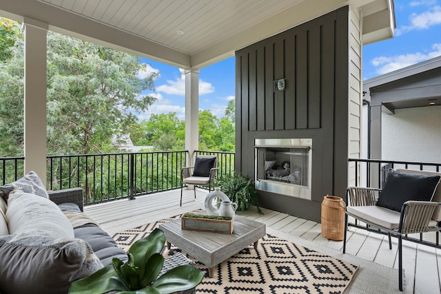 balcony featuring an outdoor living space with a fireplace