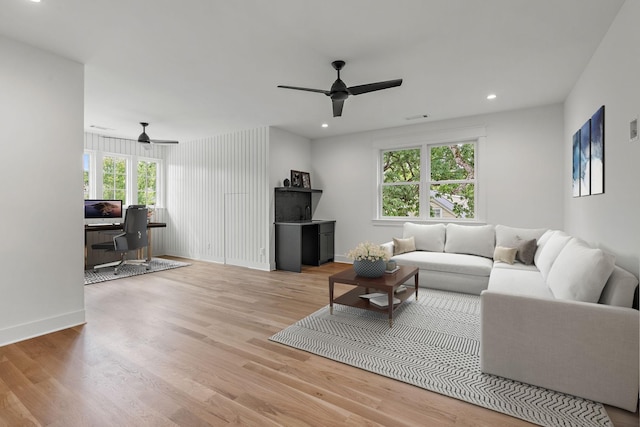 living room with ceiling fan and light wood-type flooring