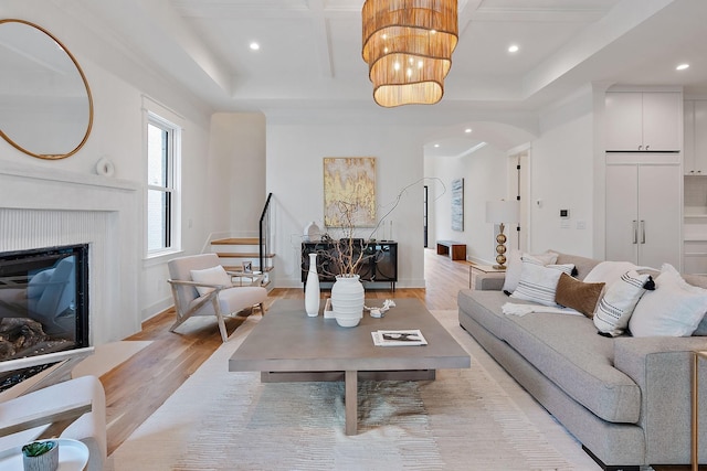 living room featuring coffered ceiling and light hardwood / wood-style floors