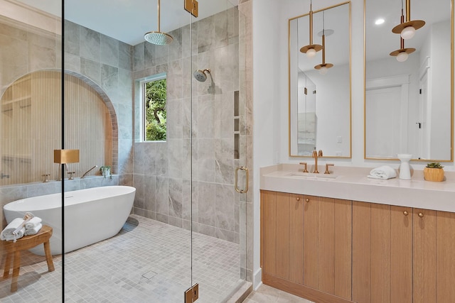 bathroom featuring shower with separate bathtub, vanity, and tile patterned floors