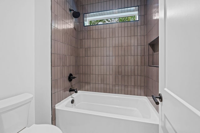 bathroom featuring tiled shower / bath and toilet