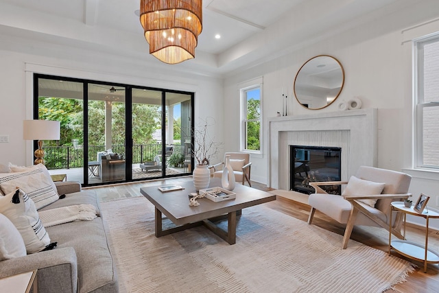 living room featuring hardwood / wood-style flooring, a premium fireplace, and an inviting chandelier