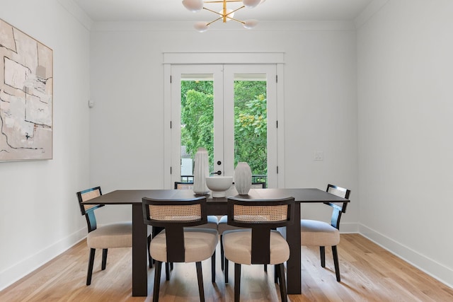 dining space with ornamental molding, light hardwood / wood-style flooring, and french doors