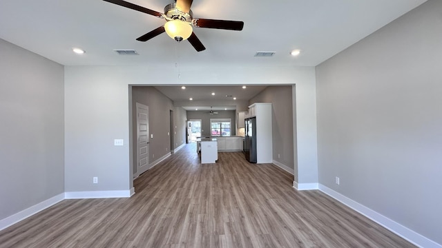 unfurnished living room featuring ceiling fan and light wood-type flooring