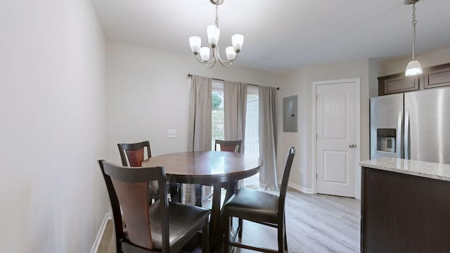 dining area featuring electric panel, a chandelier, and light hardwood / wood-style flooring