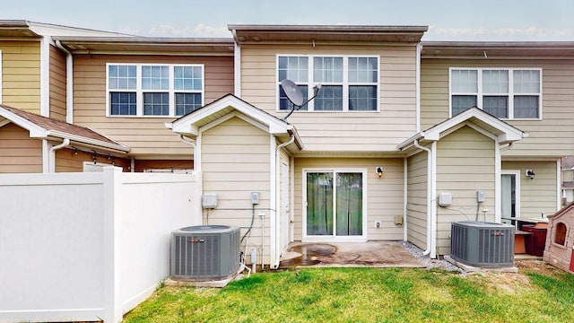 back of property with a patio, central AC, and a lawn