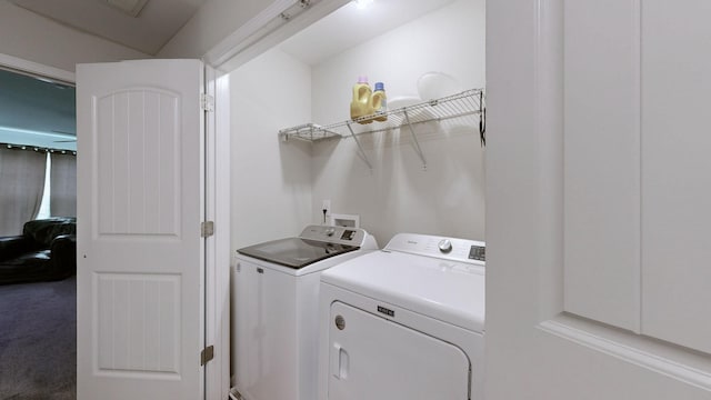 clothes washing area featuring washer and dryer and carpet