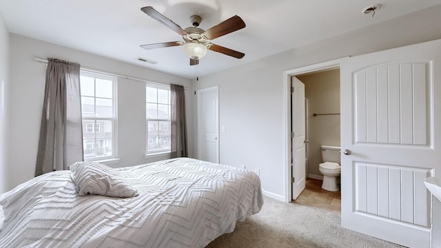 bedroom featuring ceiling fan, light carpet, and ensuite bath