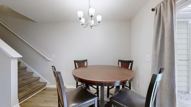 dining room with light hardwood / wood-style floors and a notable chandelier