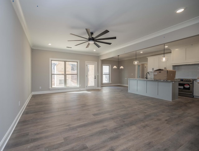 unfurnished living room with crown molding, dark wood-type flooring, sink, and ceiling fan