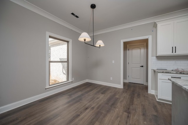 unfurnished dining area featuring ornamental molding and dark hardwood / wood-style flooring