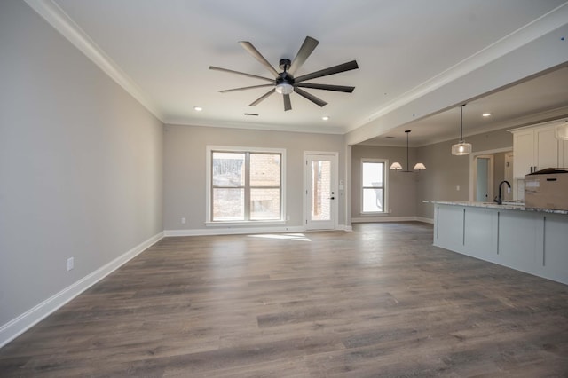 unfurnished living room featuring crown molding, sink, ceiling fan, and dark hardwood / wood-style flooring