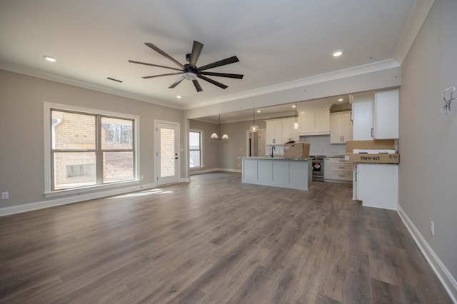 unfurnished living room featuring ornamental molding, dark hardwood / wood-style floors, and ceiling fan