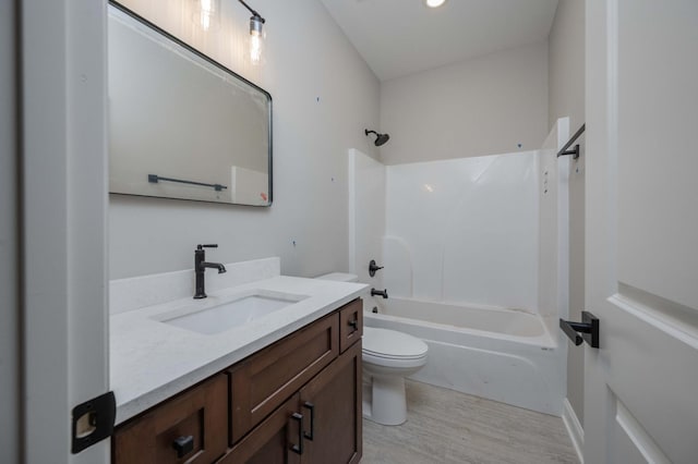 full bathroom with vanity, hardwood / wood-style floors, tub / shower combination, and toilet