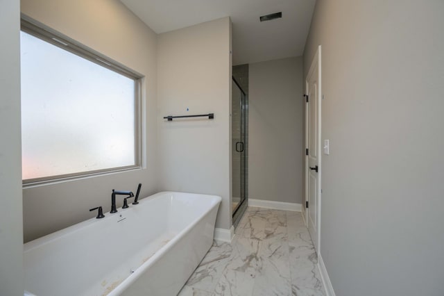 bathroom featuring shower with separate bathtub