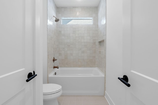 bathroom featuring toilet, tiled shower / bath combo, and tile patterned flooring