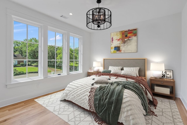 bedroom featuring a notable chandelier and light hardwood / wood-style flooring