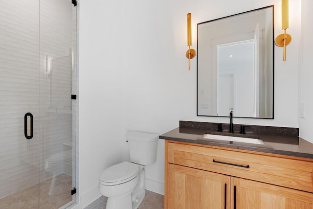 bathroom with vanity, a shower with shower door, and toilet