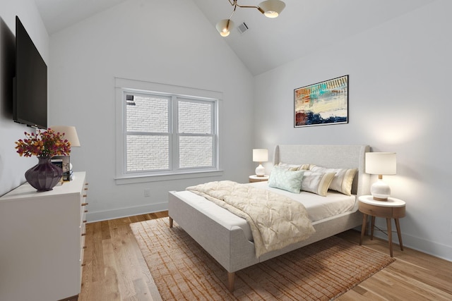 bedroom with high vaulted ceiling and light wood-type flooring